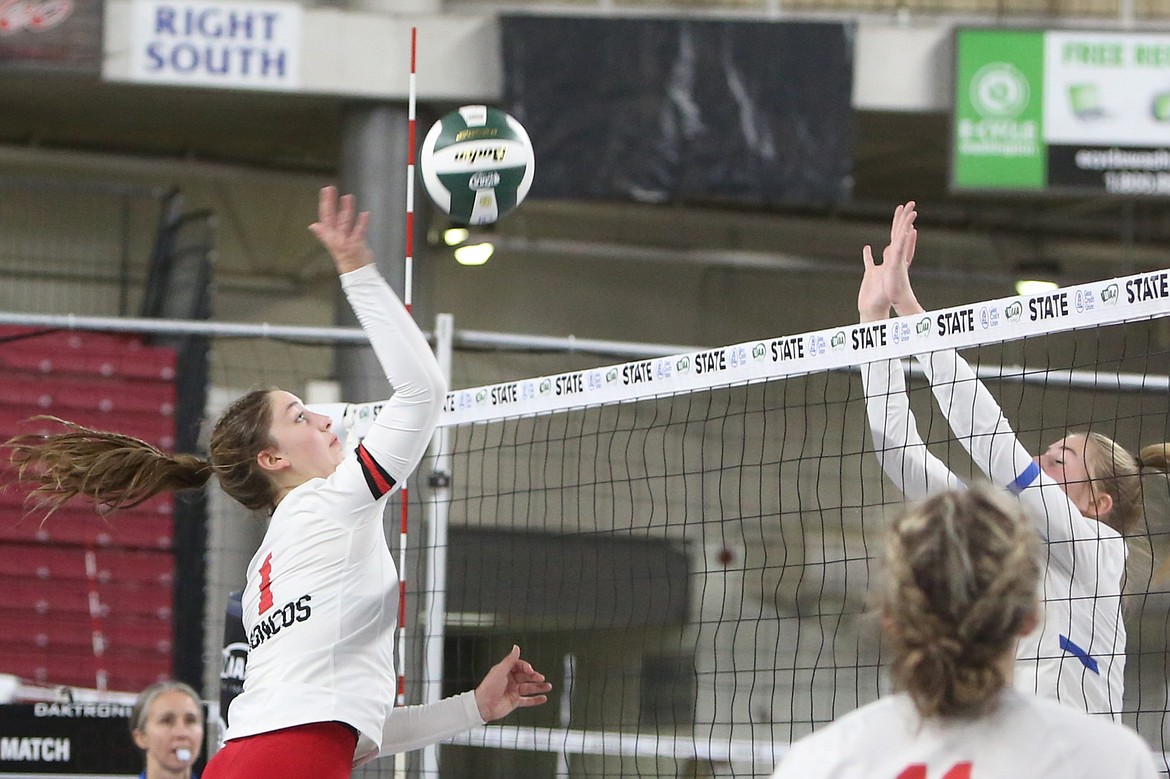 LRS junior Zoe Galbreath, left, jumps up to spike the ball over the net during last season’s state championship game against Manson.