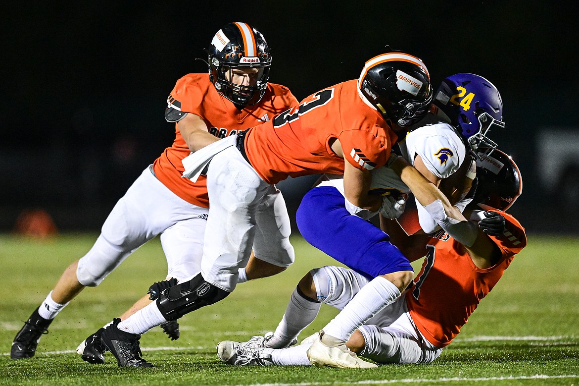 Flathead defenders Nolan Campbell (24), Lane Chivers (3) and Will Hollensteiner (7) bring down Missoula Sentinel wide receiver Kyler Haslam (24) in the second half at Legends Stadium on Friday, Sept. 20. (Casey Kreider/Daily Inter Lake)