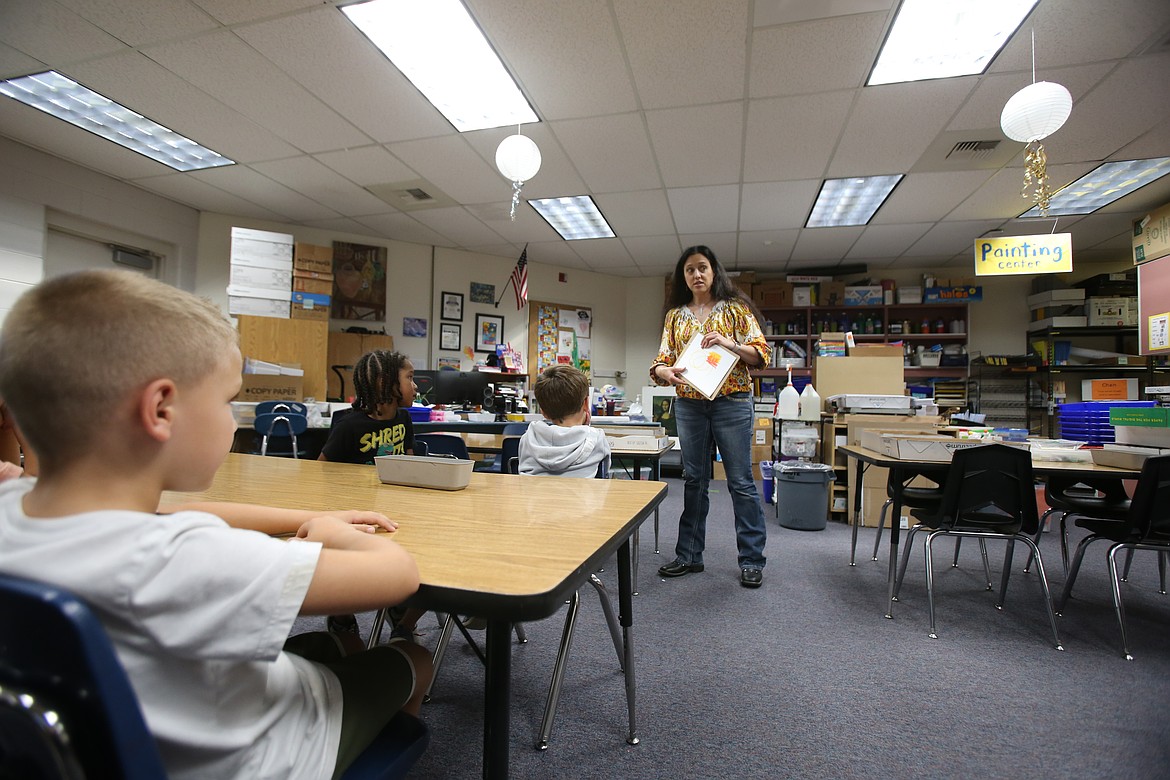 Art instructor Leatha Morgan demonstrates how to use oil pastels Wednesday as she introduces kindergartners to different art mediums.