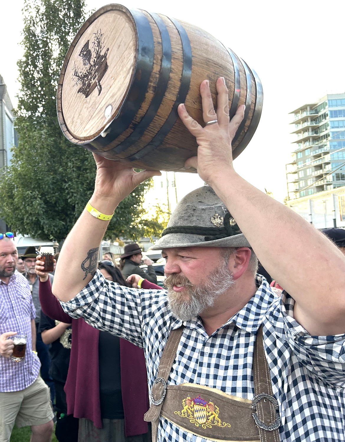 Ben Drake holds the keg high after it was emptied on the first day of Oktoberfest in Coeur d'Alene on Friday.