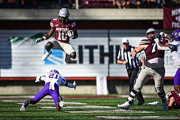 Grizzlies running back Eli Gillman (10) leaps over Western Carolina defensive back Bo Simpson-Nealy (21) on a run in the fourth quarter at Washington-Grizzly Stadium on Saturday, Sept. 21. (Casey Kreider/Daily Inter Lake)