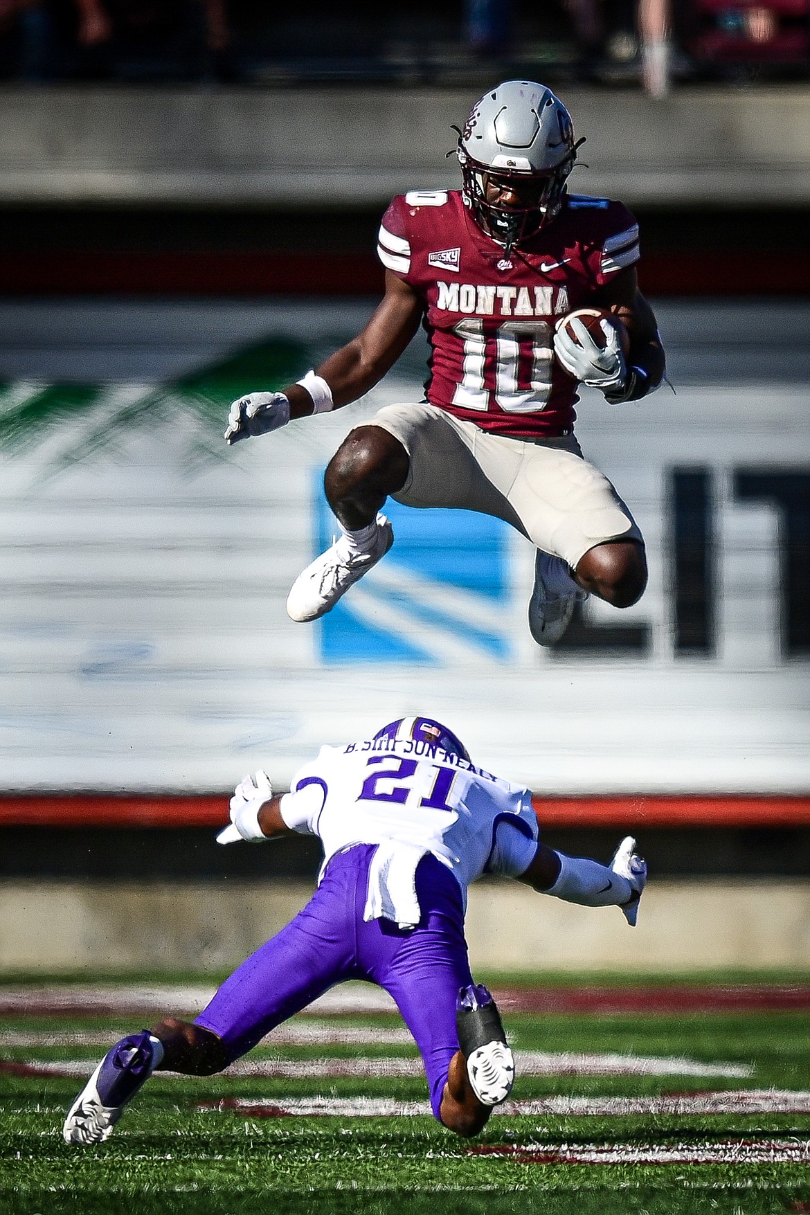 Grizzlies running back Eli Gillman (10) leaps over Western Carolina defensive back Bo Simpson-Nealy (21) on a run in the fourth quarter at Washington-Grizzly Stadium on Saturday, Sept. 21. (Casey Kreider/Daily Inter Lake)