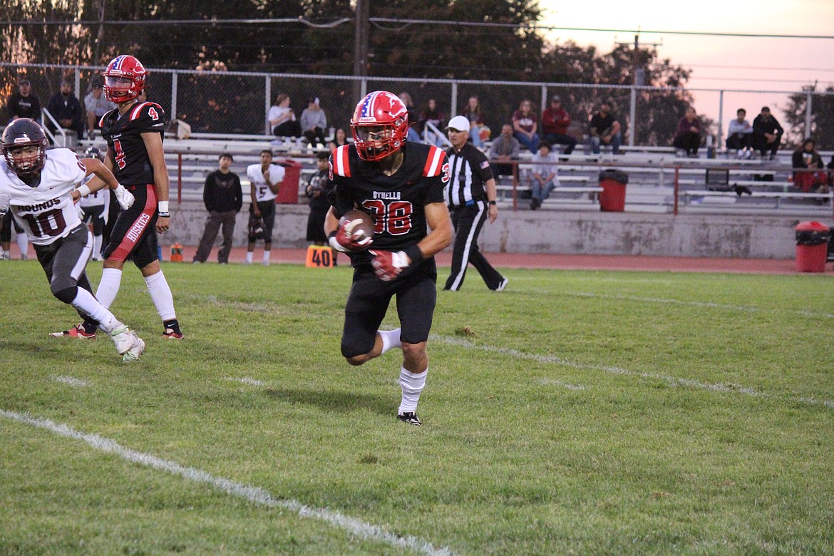 Gavin Carl (38) heads around the end. The Huskies rushed for 214 yards in Friday’s win.