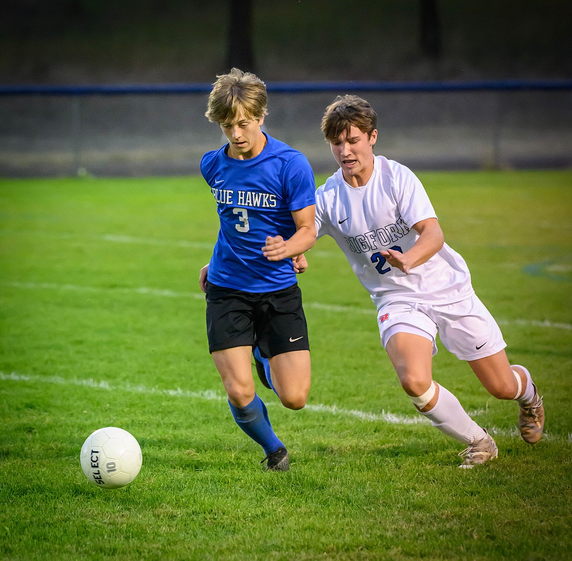 Blue Hawks sophomore Landin Baird (blue jersey) battles Bigfork's Quinn Kerr for control of the ball during their match this past Saturday in Thompson Falls.  (Photo by Tracy Scott)