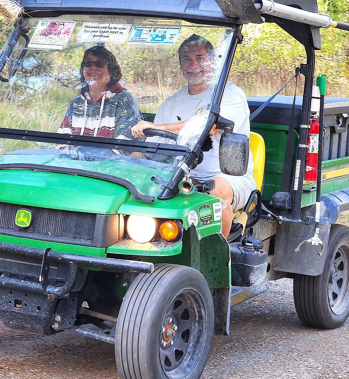 Big Arm State Park camp hosts Angie David and Allen Nutter take the 'gator to check campsites and make sure campers have everything they need. (Berl Tiskus/Leader)