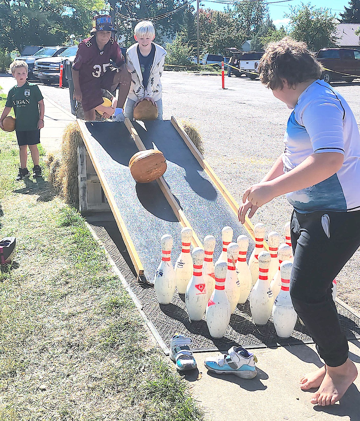 Students from the schools were setting the pins for pumpkin bowling, always a fun event at Harvest Fest. (Berl Tiskus/Leader)