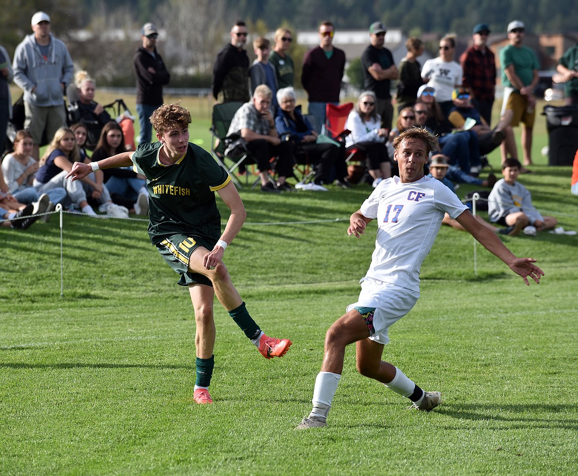 Bulldog junior midfielder Kyler Jonson crosses the ball while Wildcat Connor Zumwalt defends. (Julie Engler/Whitefish Pilot)