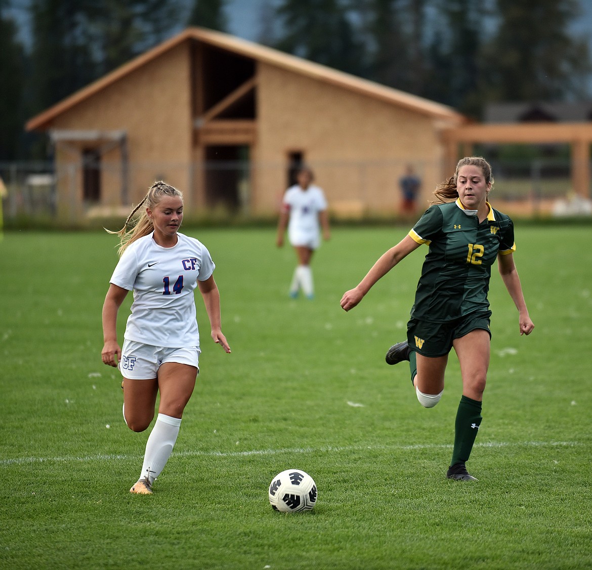 Columbia Falls midfielder Evie Dorr and Whitefish defender Charlilze Ullrich race for the ball at the game last week. (Julie Engler/Whitefish Pilot)