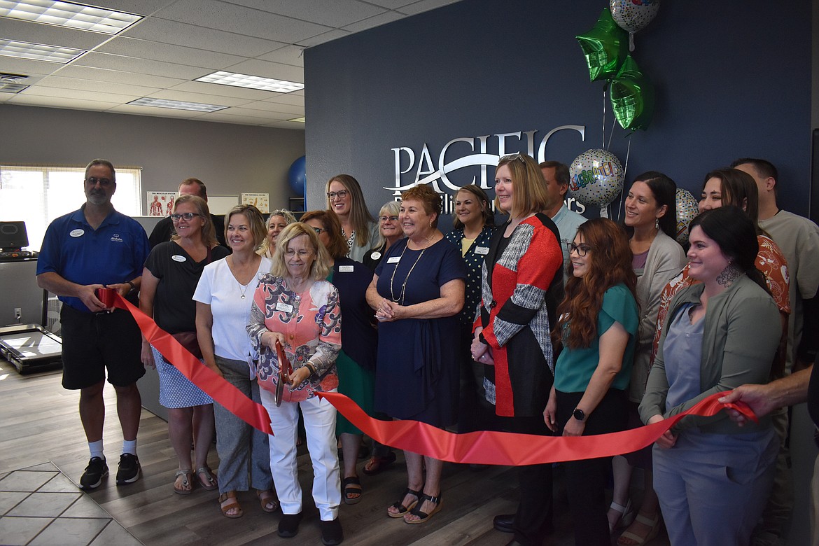 Pacific Rehabilitation Center CEO Regine Neiders cuts the ribbon on the company’s new Moses Lake facility, flanked by (from left) Clinic Director Maggie Vennarucci, Clinic Administrator Susie Soto (behind Neiders), Business and Program Development Director Bobbi Meins, Clinical Manager Mary Spores and Administrative Assistant Erika Garza, as well as members of the business community and the Moses Lake Chamber of Commerce.