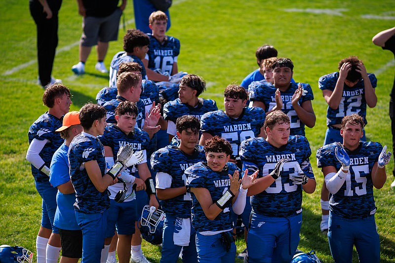 Warden players clap in celebration during a game this season. The Cougars improved to 3-0 after Saturday’s come-from-behind win over Tonasket.