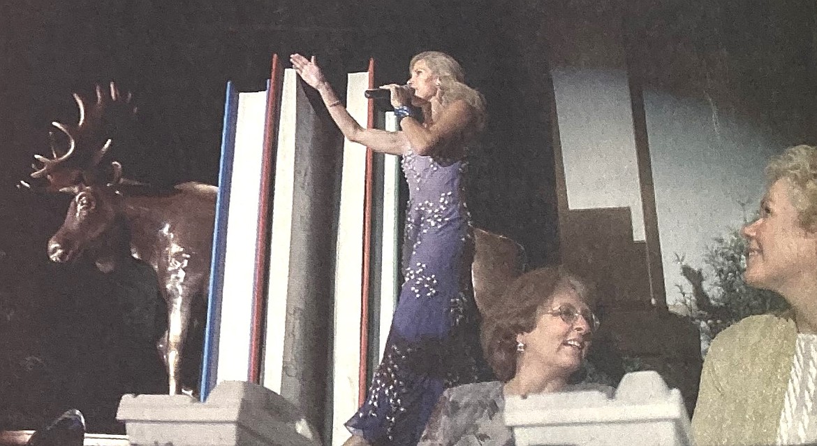 In 2004, auctioneer Amy Smith, standing, called for bids on artist Rann Haight’s “Moose Ends,” while Lyn Gerhard, left foreground, and Marilyn Griffits watched.