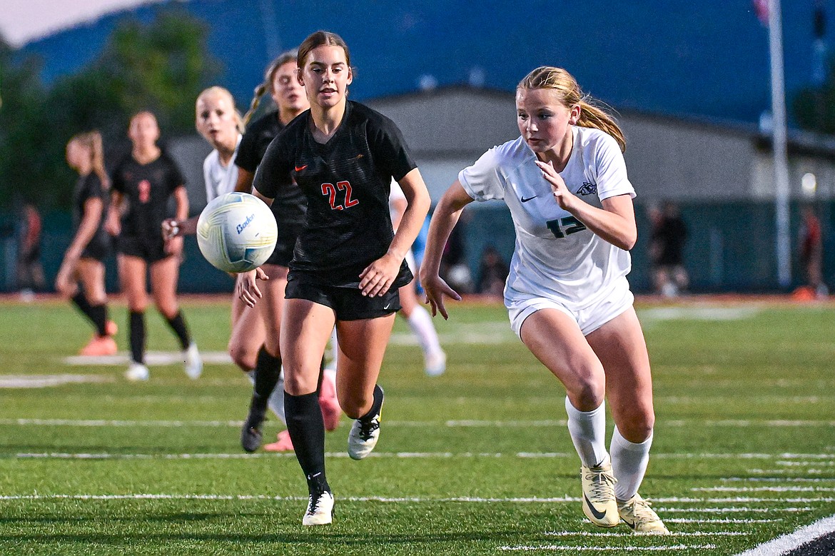 Flathead's Camas Bushnell (22) and Glacier's Lucy Holloway (12) chase down a ball in the second half at Legends Stadium on Thursday, Sept. 26. (Casey Kreider/Daily Inter Lake)