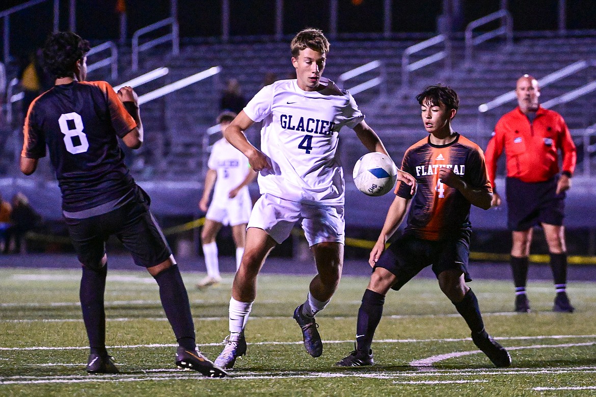 Glacier's Creed Norick (4) pushes the ball upfield between Flathead's Nico Erazo Duenas (8) and Thomas Dixon (4) in the second half at Legends Stadium on Thursday, Sept. 26. (Casey Kreider/Daily Inter Lake)