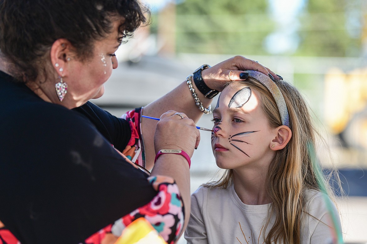 Andrea Robinson, owner of Montana Art and Soul, paints a young girls' face during a groundbreaking ceremony for Samaritan House's expansion project on Thursday, Sept. 26. (Casey Kreider/Daily Inter Lake)