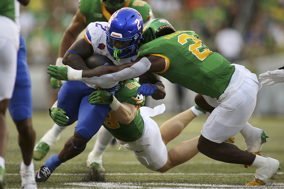 Boise State running back Ashton Jeanty, left, fights for extra yards during a game against Oregon on Sept. 7. Jeanty has rushed for 586 yards and nine touchdowns on 56 carries this season, the second-most yards and tied for the second-most touchdowns in the FBS.