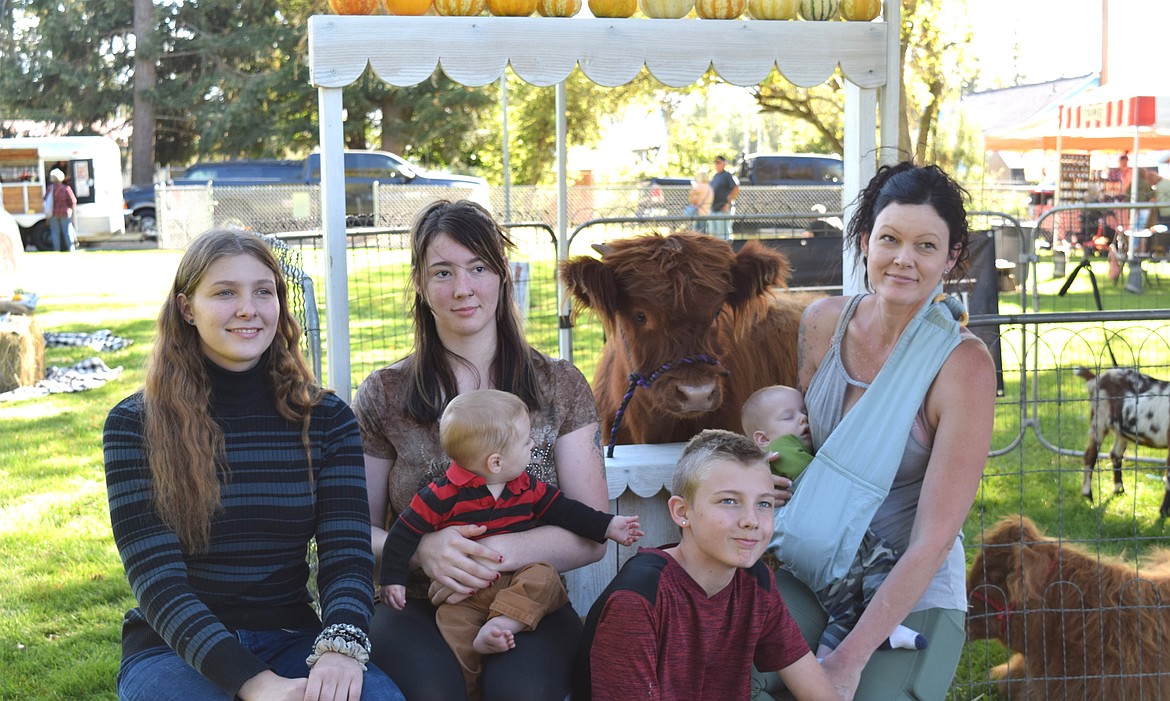 From left: Willow Holman, Summer Holman with baby Luke, Chace Holman and Julia Holman with baby Deen pose with Norman the Highland Cow at the Athol Fall Farmers Festival.