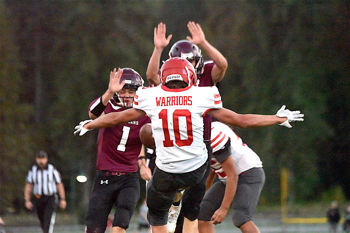 Troy's Wyatt Schertel (1) and Trapper Savage put pressure on Arlee's punter during the second half of the game Friday, Sept. 27, 2024. (Scott Shindledecker/The Western News)