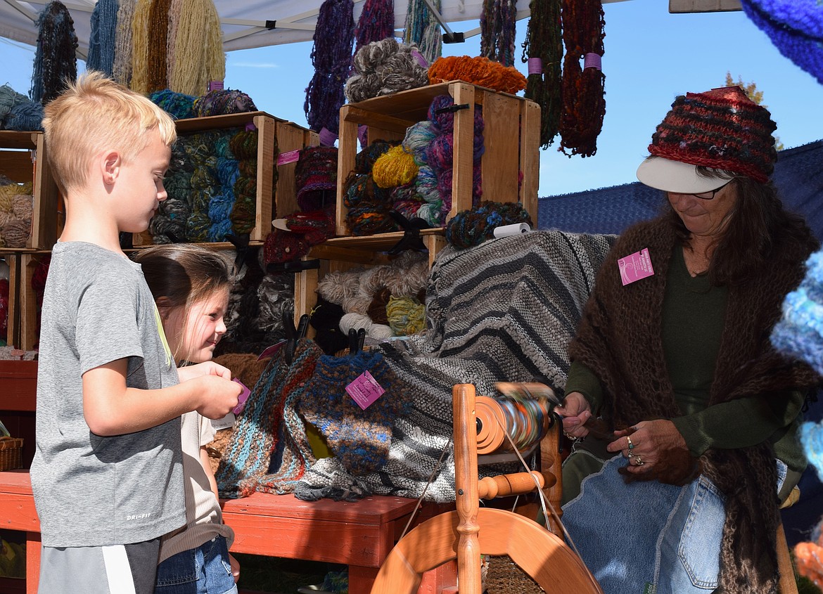 Karson, 7, and Kenlee, 4, watch hand-spun yarn be made by Garden Party Fibers at Saturday's Fall Fest in Hayden.