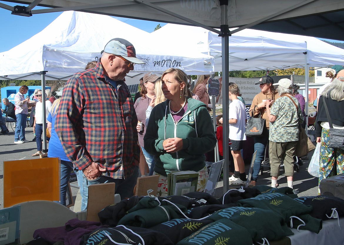 Marcy Timblin, director of communications for Kaniksu Land Trust, right, takes to a resident who stopped by the land trust's booth at Saturday's Neighborhood Fair at Winter Ridge Natural Foods.