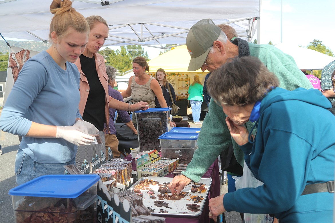 Gracie and Julie Breuer hand out samples of their handcrafted chocolate at Saturday's Neighborhood Fair at Winter Ridge Natural Foods.