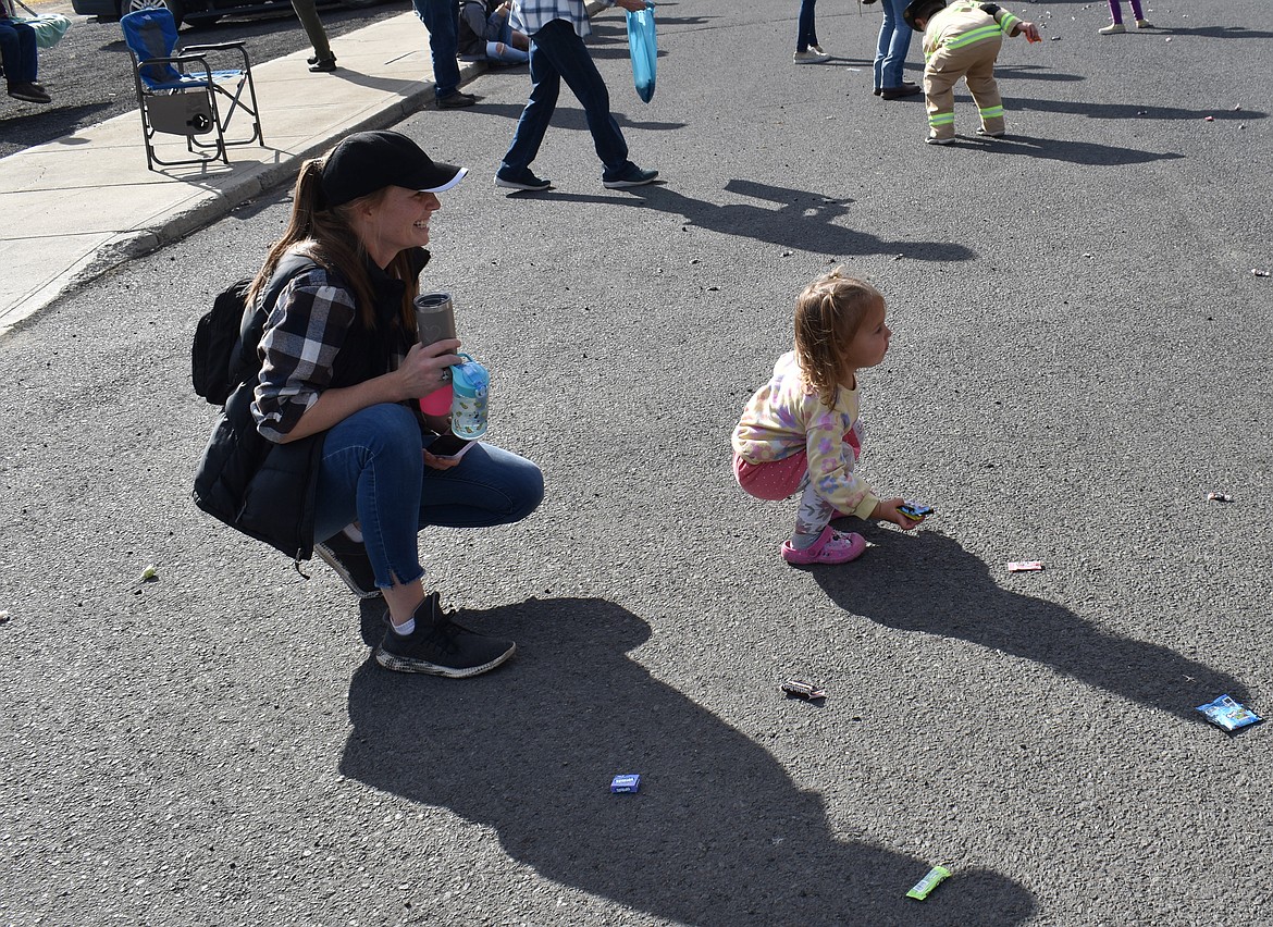 Marlee Jo Victorino, 2, picks up some candy while her mom, Megan Victorino, looks on at the Almira Country Fair parade Saturday.