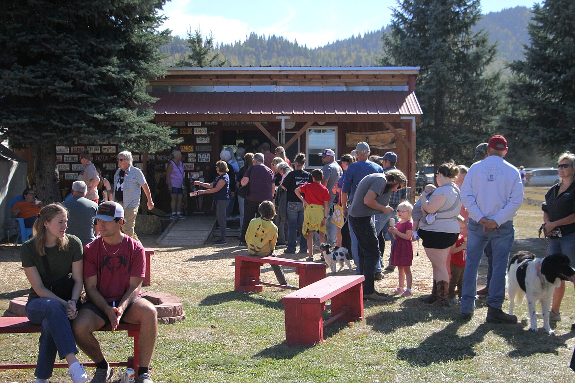 Customers line up in front of a shed to purchase Snow Valley's organic garlic on Saturday.