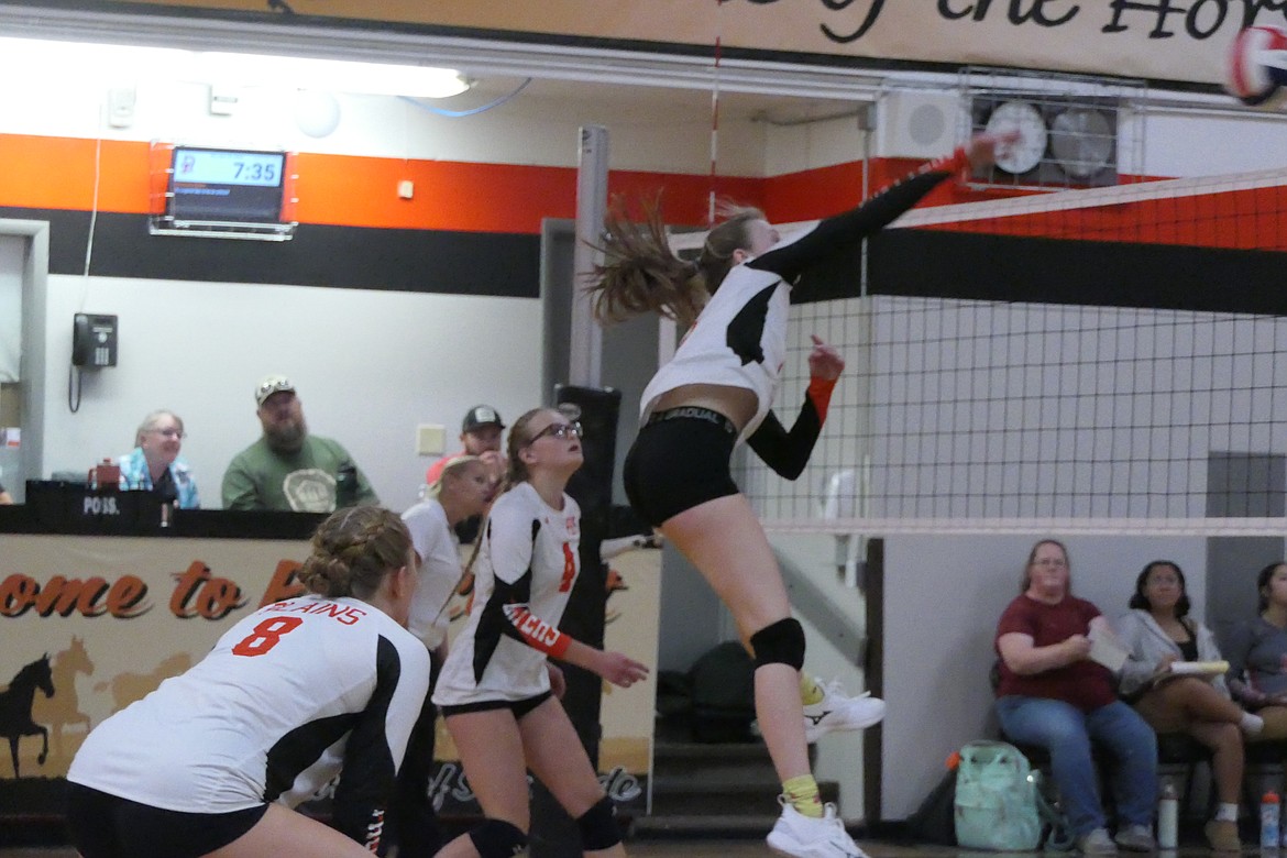 Three Trotters players converge at the net for a return shot during their match this past week with Arlee, in Plains.   (Chuck Bandel/VP-MI)