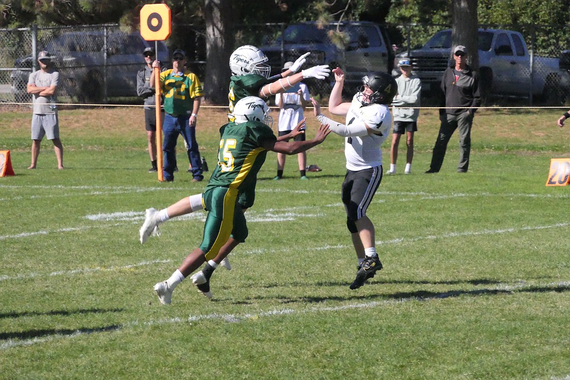 Two St. Regis defenders put pressure on the Seeley-Swan quarterback during their Homecoming game this past Saturday in St. Regis.  (Chuck Bandel/VP-MI)