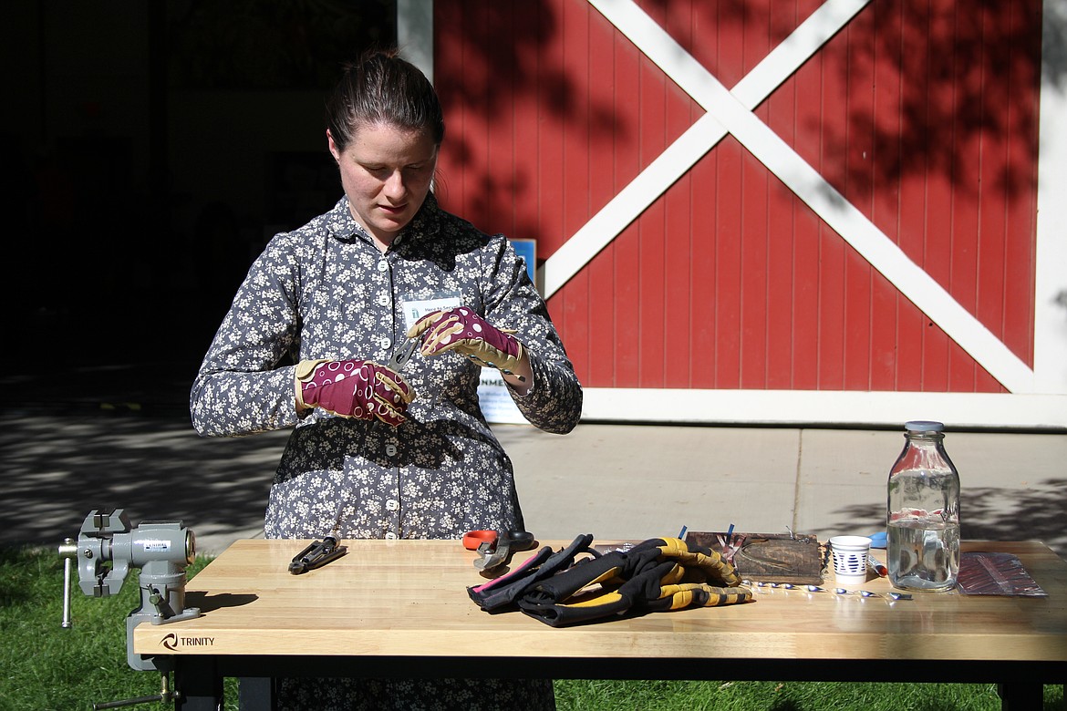 Megan Aldrich works on making tin “icicles” during the Celebration of Harvest and Culture at the Quincy Valley Historical Society and Museum.