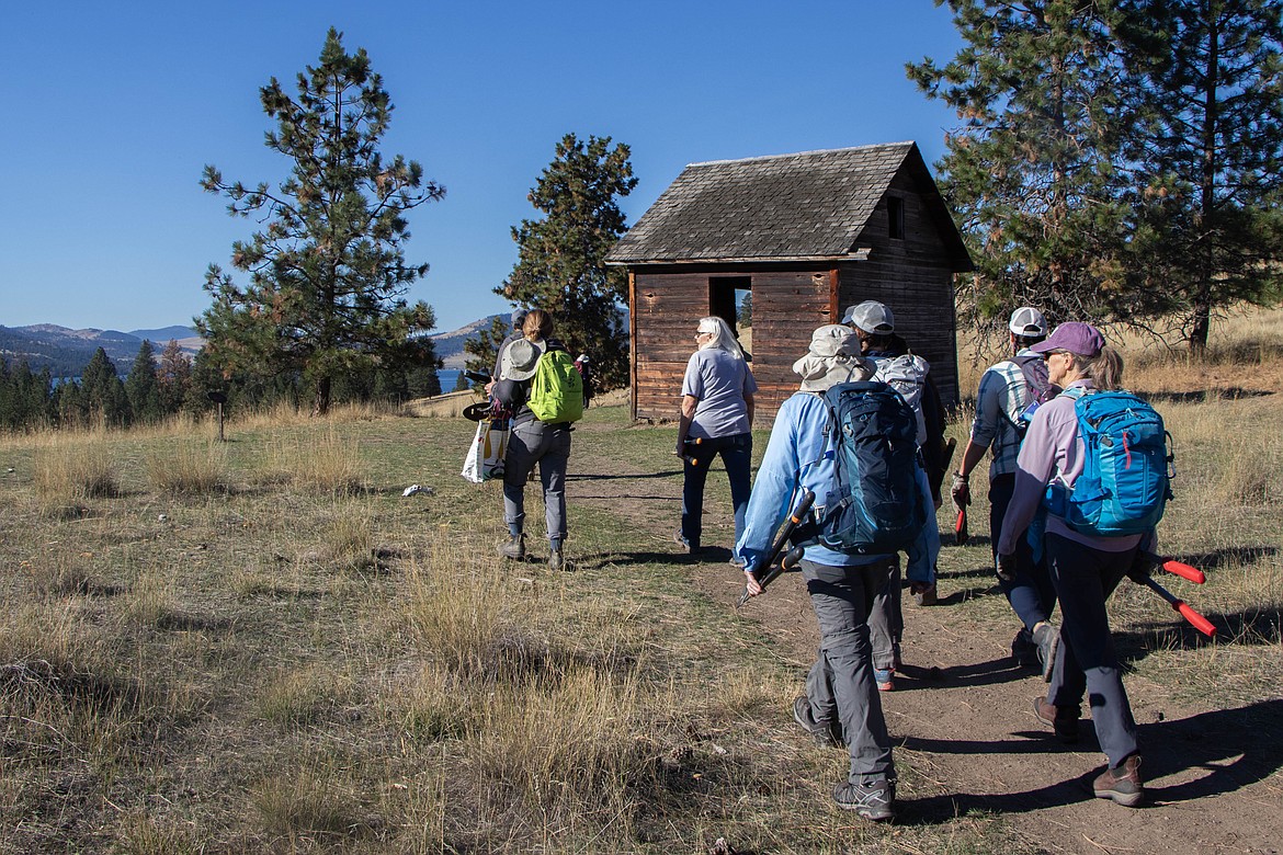 Volunteers hike to one of two homestead structures on Wild Horse Island, built in the early 1900s, during a volunteer event on Wild Horse Island through Montana Fish, Wildlife and Parks on Sept. 28, 2024. (Kate Heston/Daily Inter Lake)