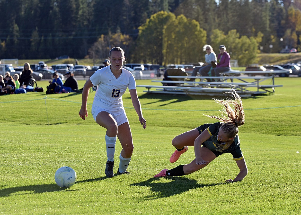 Taylor Dorvall takes a fall after battling for the ball with a Libby midfielder at Smith Fields on Thursday. (Julie Engler/Whitefish Pilot)