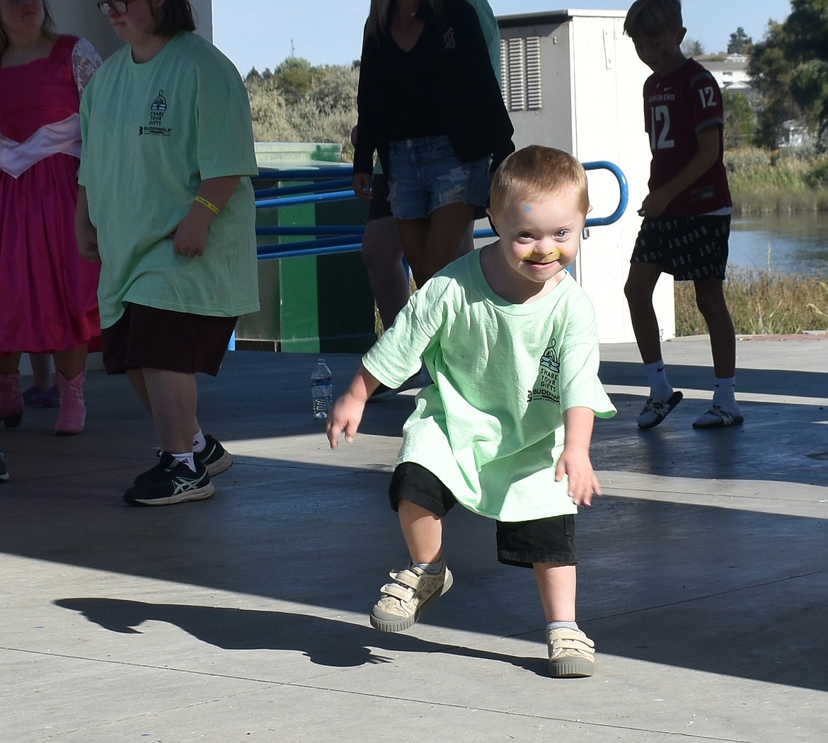 Five-year-old Dayton Delange rocks out on the stage at the Centennial Amphitheater at McCosh Park in Moses Lake Saturday before the annual Down Syndrome Buddy Walk.