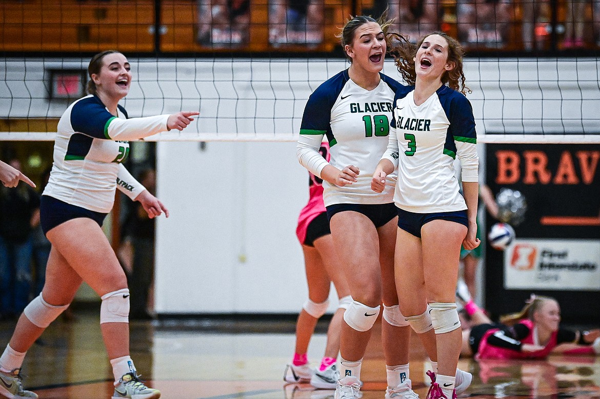 Glacier's Sydnie Ryan (20, Allie Krueger (18) and Cassidy Daniels (3) celebrate after a point against Flathead at Flathead High School on Thursday, Oct. 3. (Casey Kreider/Daily Inter Lake)