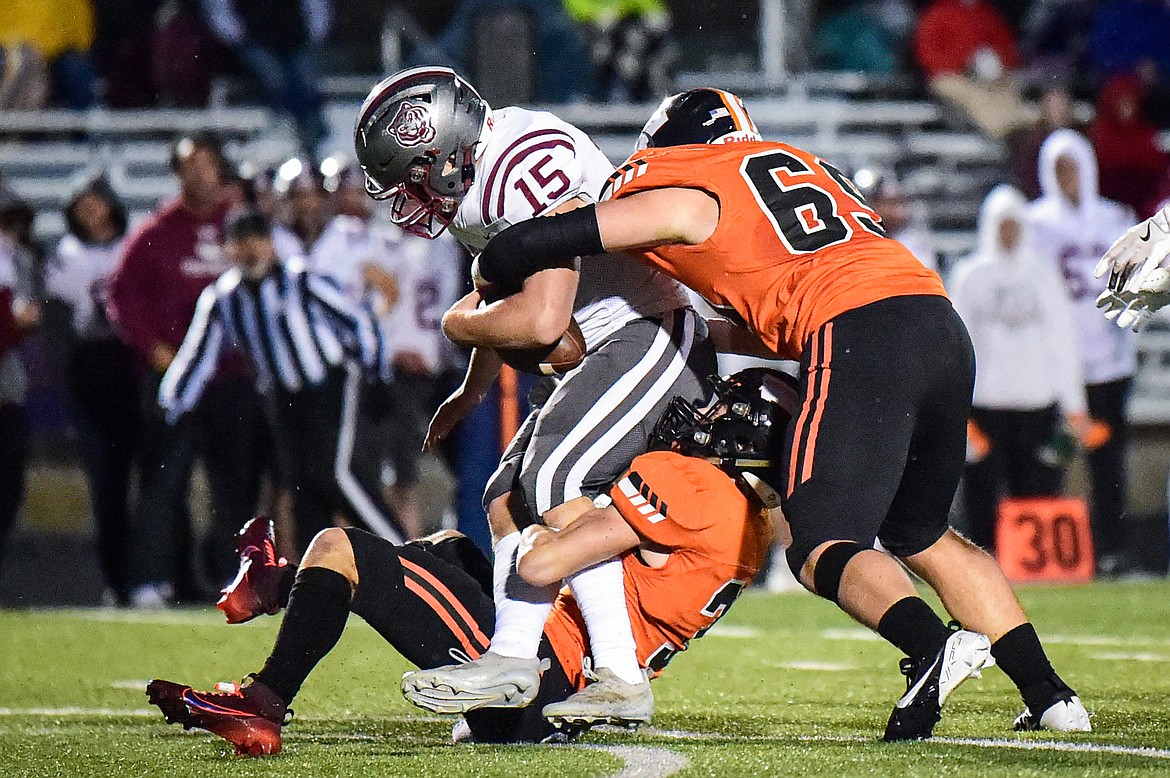 Flathead defenders Lane Chivers (3) and Kohen Rilley (69) wrap up Helena running back Trygve Braun (15) in the first quarter at Legends Stadium on Friday, Oct. 4. (Casey Kreider/Daily Inter Lake)