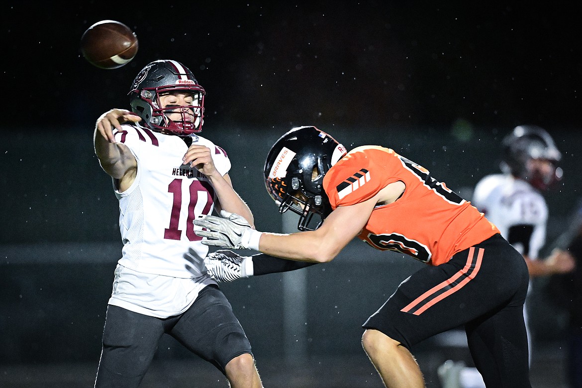 Flathead defensive lineman Hudson Capser (60) hits Helena quarterback Mac Lundstrom (10) as he throws in the first quarter at Legends Stadium on Friday, Oct. 4. (Casey Kreider/Daily Inter Lake)