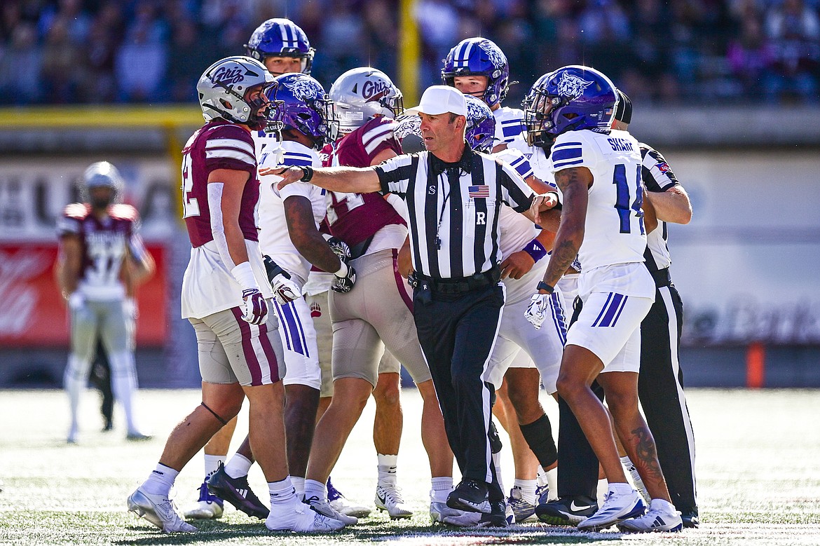 A referee separates Montana and Weber State players after an unsportsmanlike conduct penalty in the first quarter against the Grizzlies at Washington-Grizzly Stadium on Saturday, Oct. 5. (Casey Kreider/Daily Inter Lake)