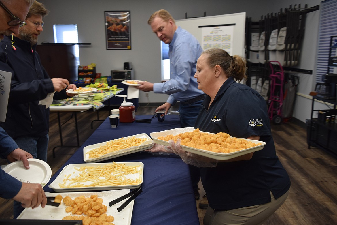 Employees of Simplot shuffle in freshly made potato goods for the Association of Washington Business bus tour group Oct. 4.