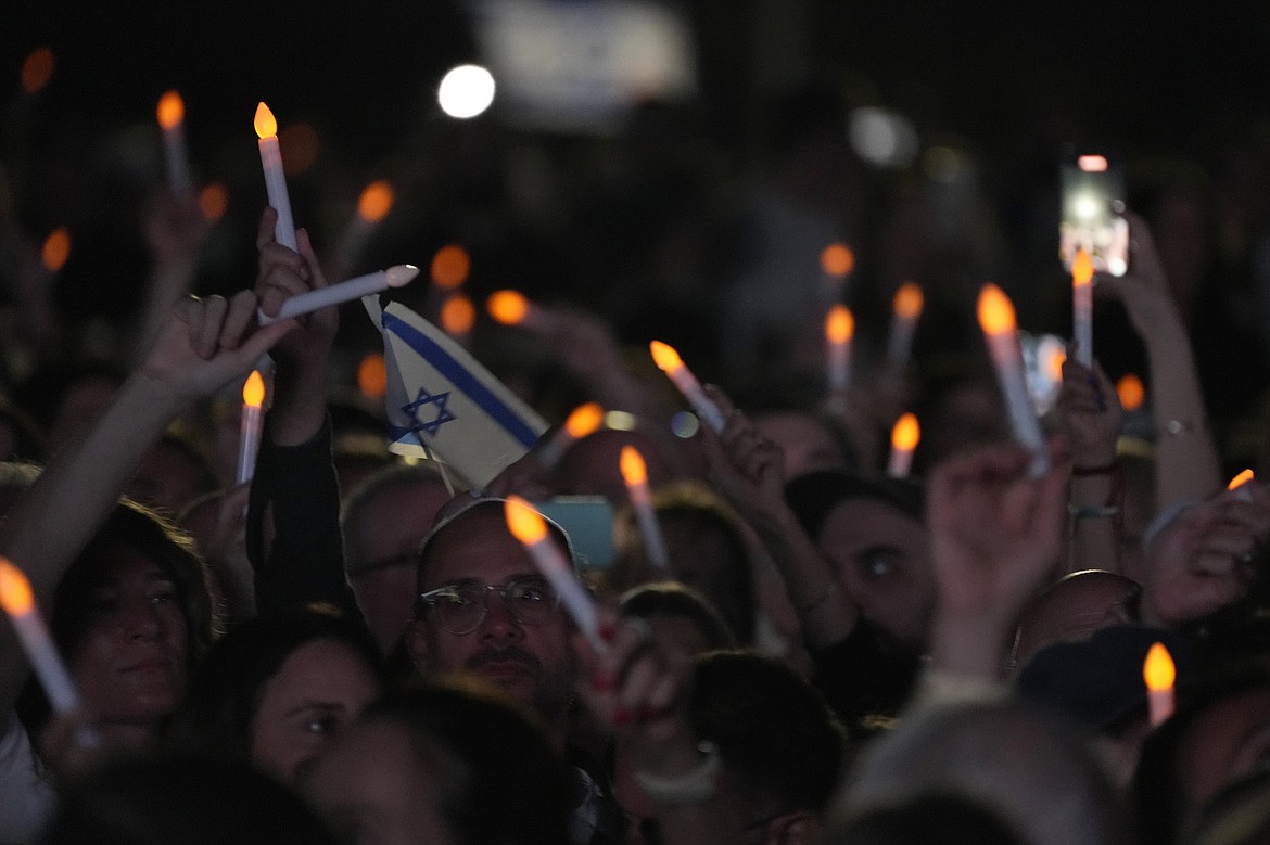 Members of the Jewish community wave electronic candles as they gather at a park in Sydney, Australia, on Monday, Oct. 7, 2024, as mourners marked the anniversary of the Oct. 7, 2023, Hamas attack. (AP Photo/Rick Rycroft)