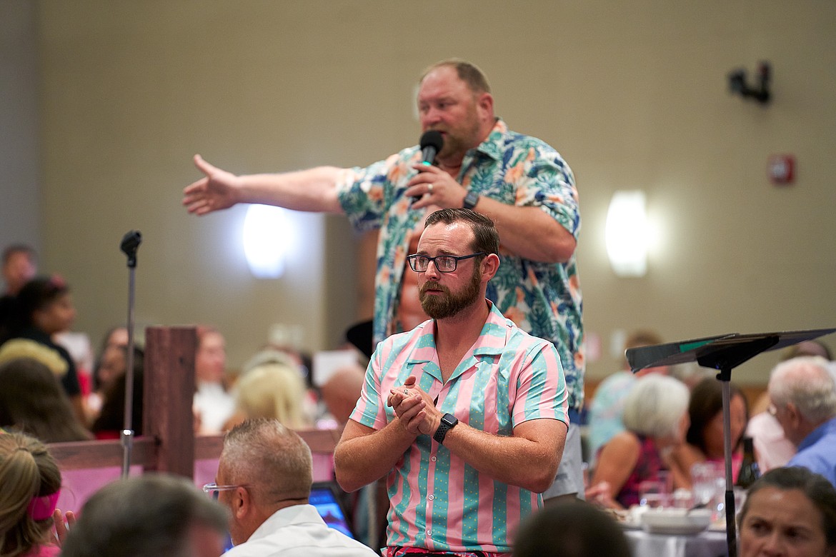 Jacob Barth, front, scans the crowd for bids as auctioneer Chuck Yarbro Jr. Keeps up a steady patter at the Boys & Girls Club auction Saturday. The event raised an estimated $250,000.