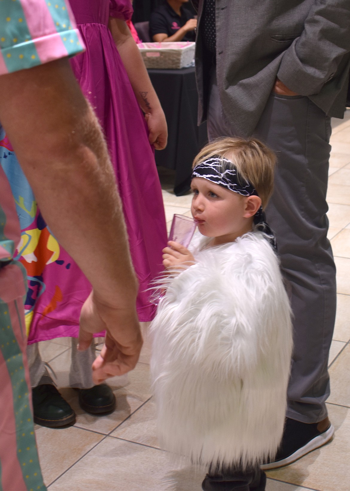 Three-year-old Jax Barth sips apple cider in his Mojo Dojo Ken outfit at the Boys & Girls Club auction Saturday.