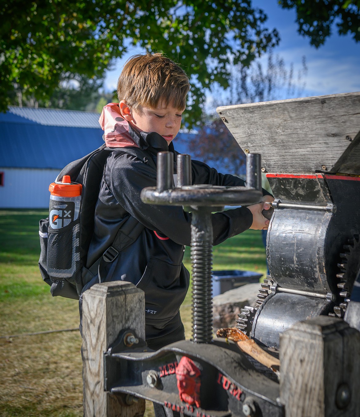 Plains third grader Legend Corby tries out the apple press sponsored by Bruce Beckstead and Marolyn Carr. (Tracy Scott/Valley Press)