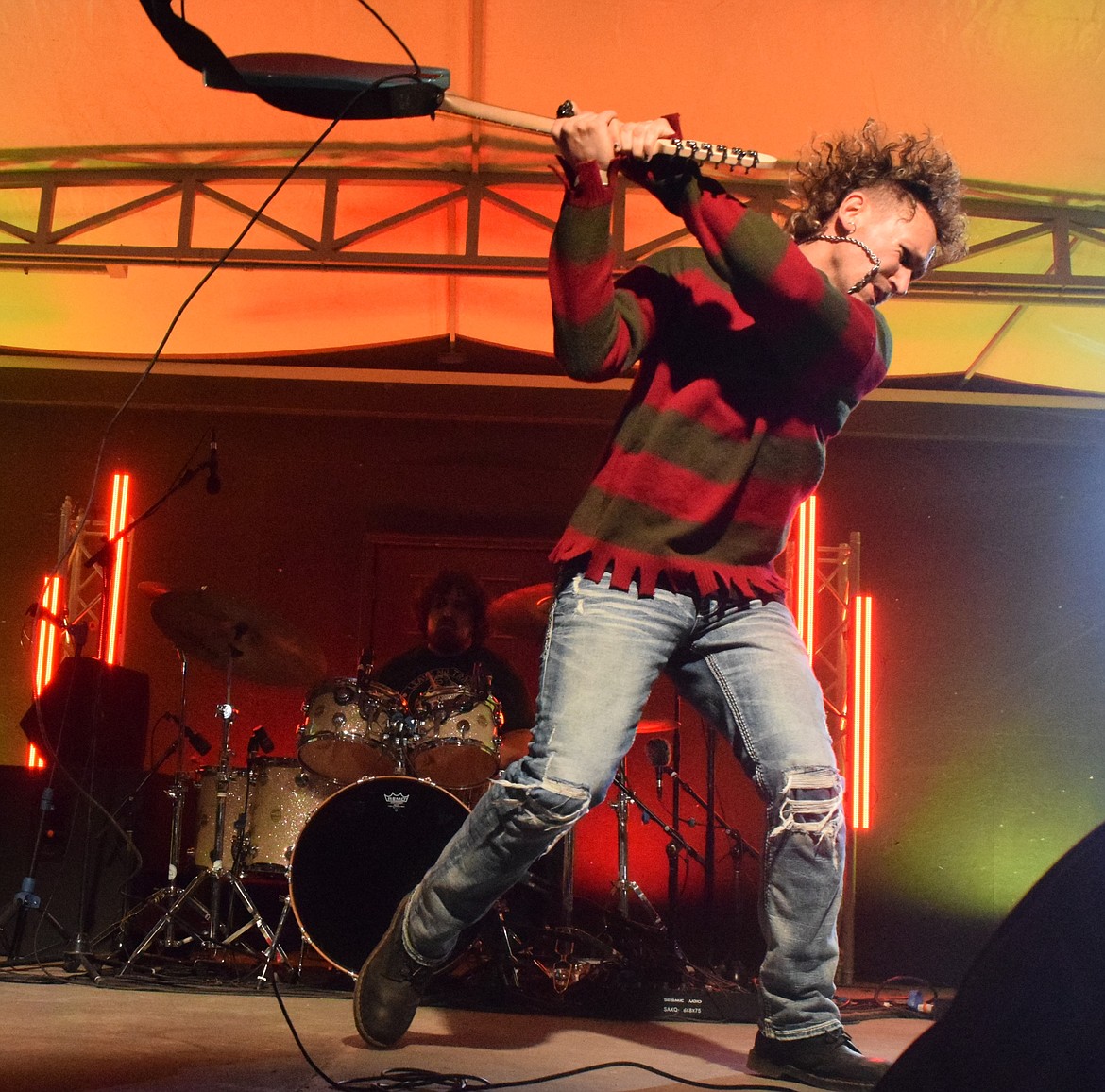 Nick Stone, singer and guitarist for Nevermind, a Seattle tribute band honoring Nirvana, smashes his guitar during the final song of their set at ’90s Flannel Fest Sat. night.