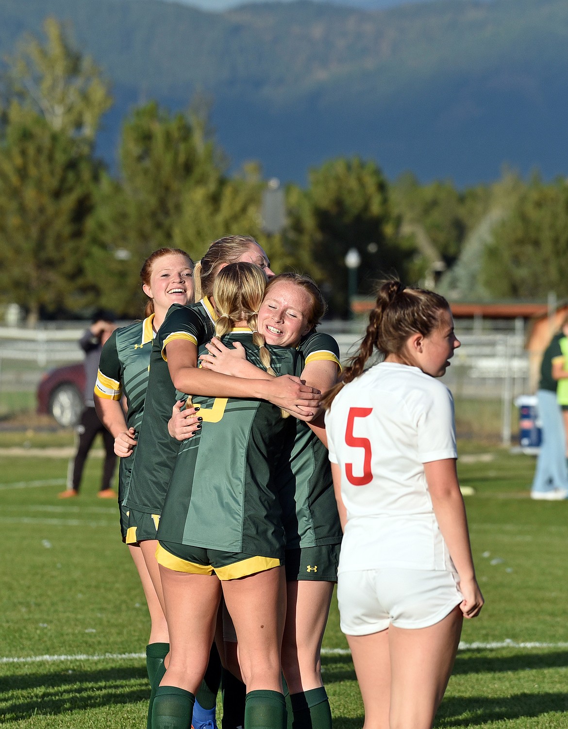 A team hug celebration after Georgia Morell's goal in the homecoming game last week. (Julie Engler/Whitefish Pilot)