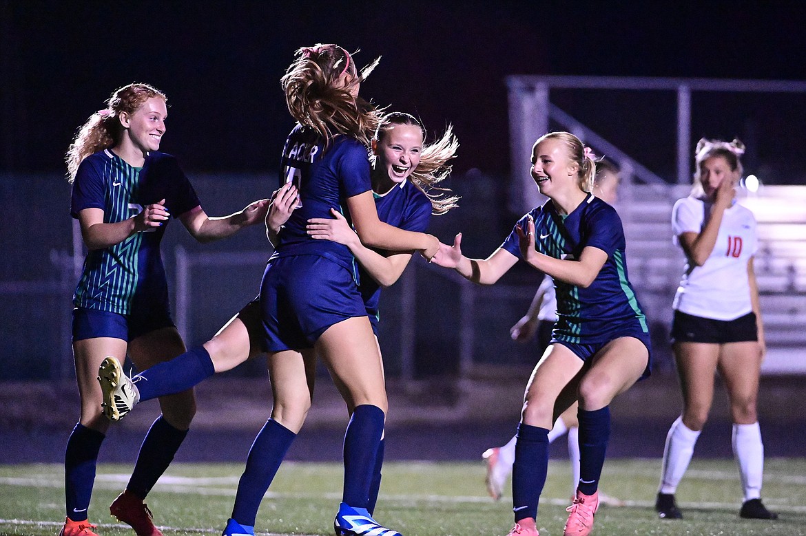 Glacier's Lucy Holloway (12) celebrates with Reese Ramey (22), Gracie Winkler (10) and Neve Travis (5) after her second goal of the night against Flathead at Legends Stadium on Tuesday, Oct. 8. (Casey Kreider/Daily Inter Lake)