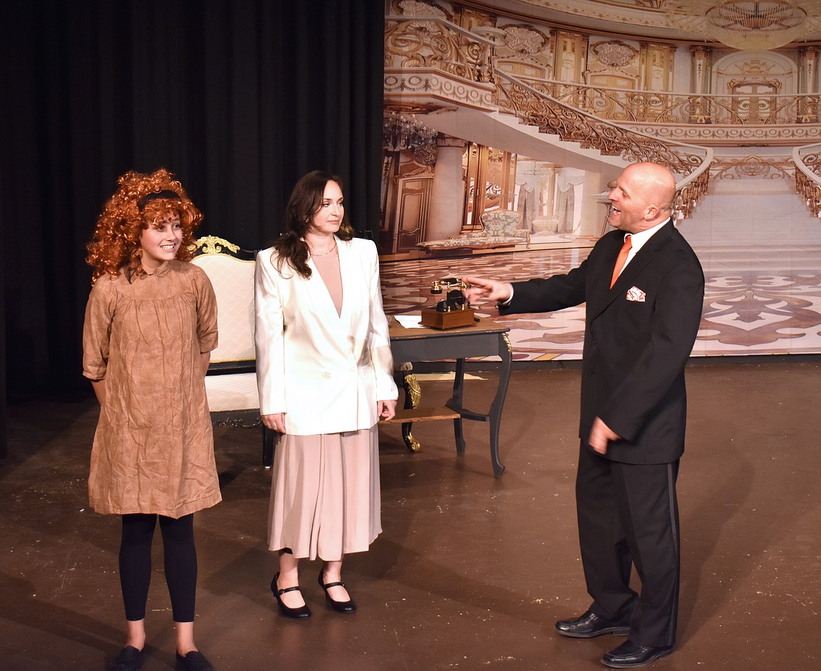 Annie (Carlee Howard), left, introduced by Grace (Jessica Stredwick) meets Oliver “Daddy” Warbucks (Jason Noble) for the first time. Noble said he was probably the only man who auditioned for the role who wouldn’t have had to shave his head.