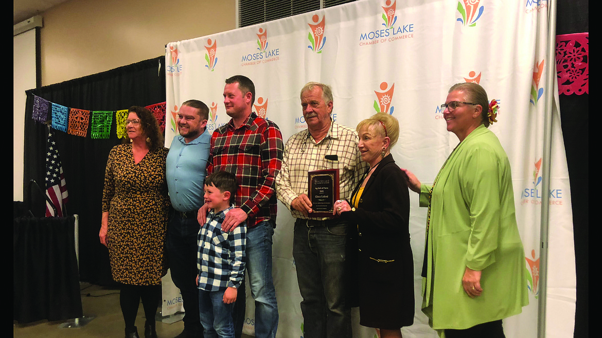 Moses Lake Chamber of Commerce Executive Director Debbie Doran-Martinez, right, presents Glenn Leland and family with his 2023 Ag Hall of Fame award. This year’s awards will be given Tuesday at the Grant County Fairgrounds.