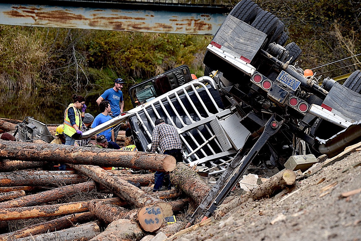 First responders work at the scene of a log truck crash on Highway 56 in Sanders County Wednesday, Oct. 9, 2024. The truck left the road and crashed into the Bull River. (Scott Shindledecker/The Western News)