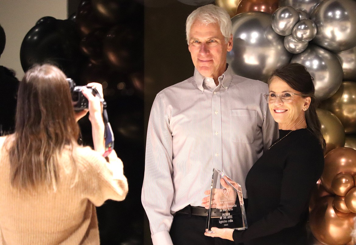 Board chair Scott Hoskins poses with the Patron of the Arts award presented to ignite cda. He is joined by Coeur d'Alene City Councilor Kiki Miller.