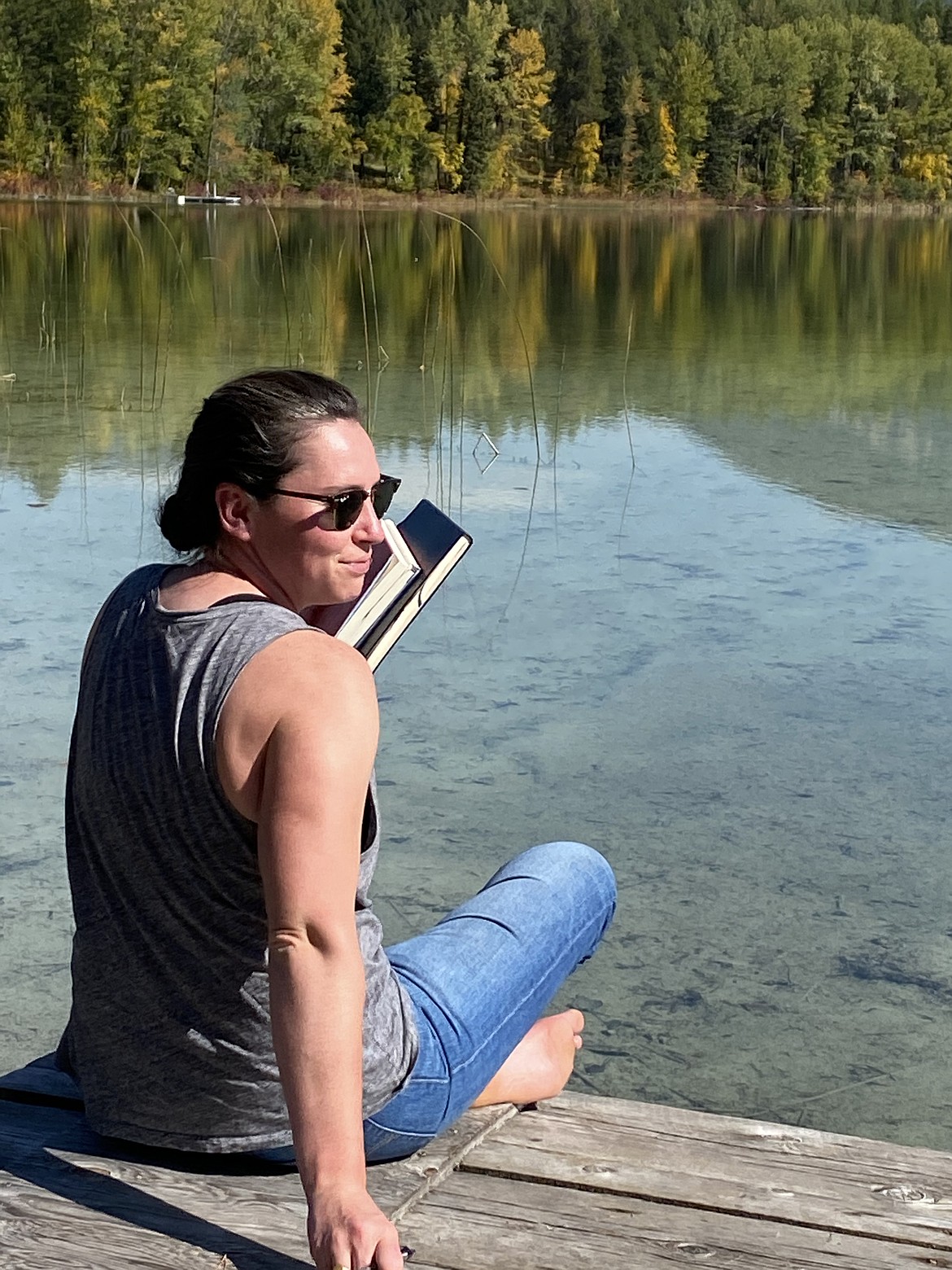 Emily Rea, 33, of West Glacier is seen journaling on a dock. Rea has been missing since July 16, 2024. (photo provided)