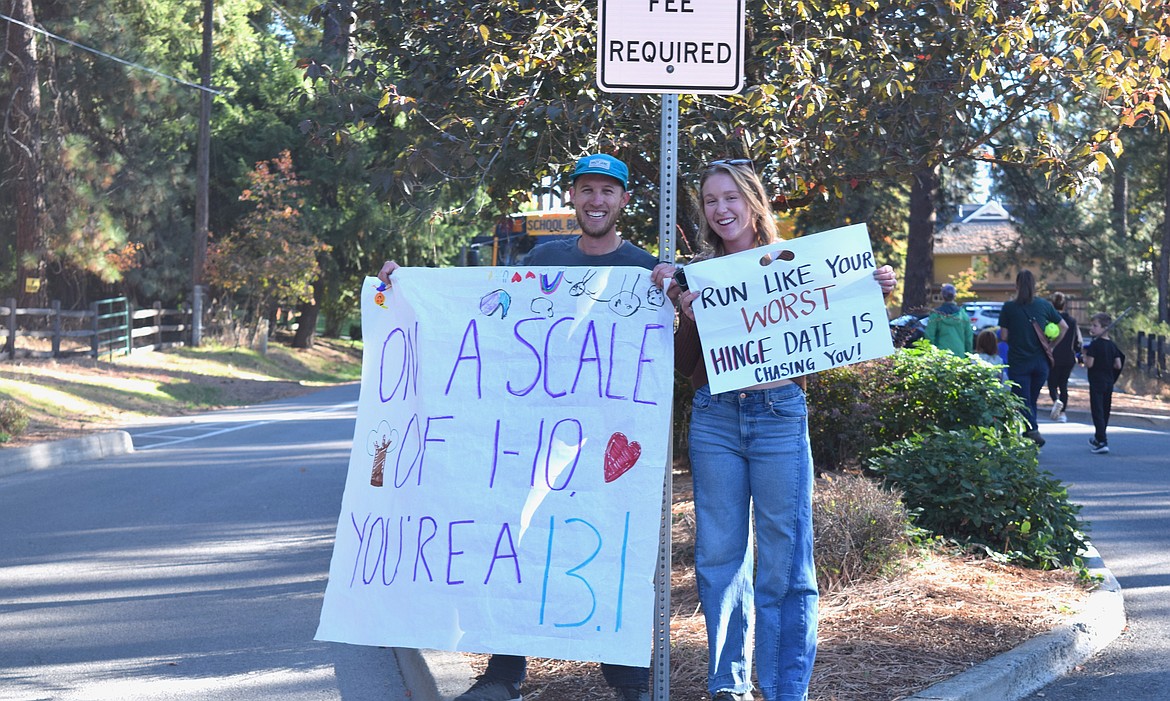 Community members supported runners in Saturday's Hayden Lake Marathon with signs as the runners neared the finish line.